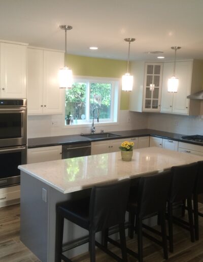 A kitchen with white cabinets and stainless steel appliances.